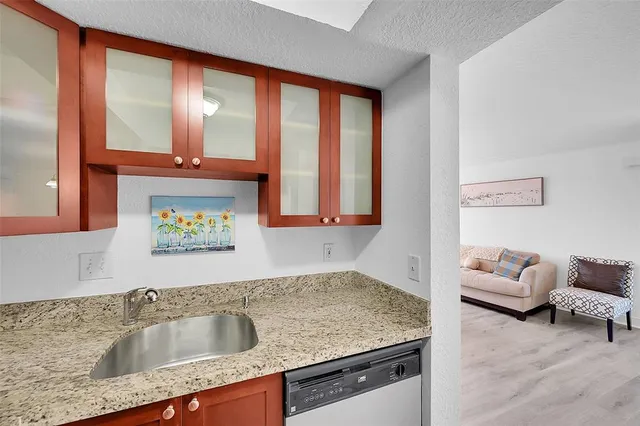 a bathroom with a granite countertop sink and a window