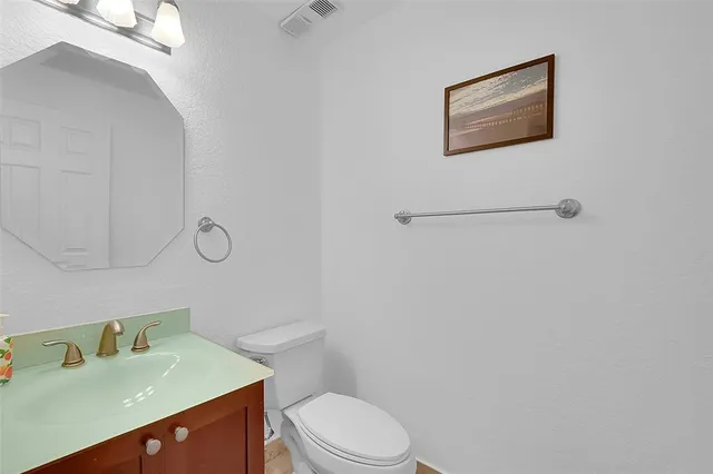 a bathroom with a toilet sink vanity and mirror