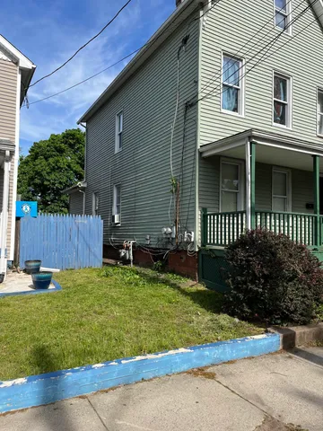 a view of a house with a yard and sitting area
