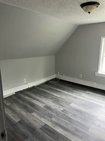a white toilet sitting next to a white wall