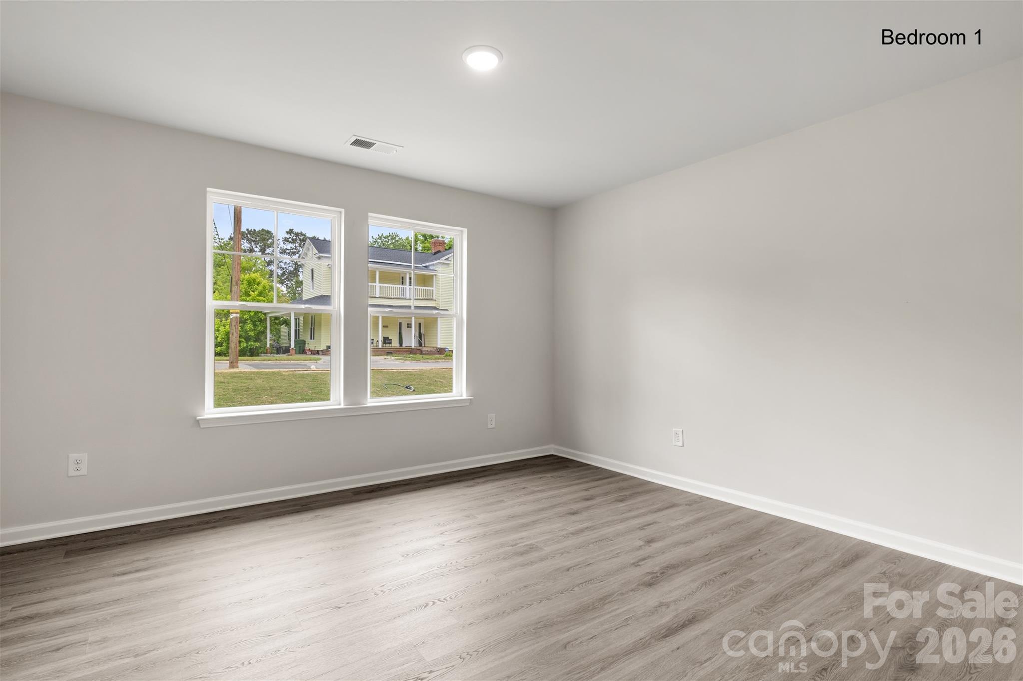 302 Elm Street Lancaster, SC 29720 - Photo 11 of 25 an empty room with wooden floor and windows