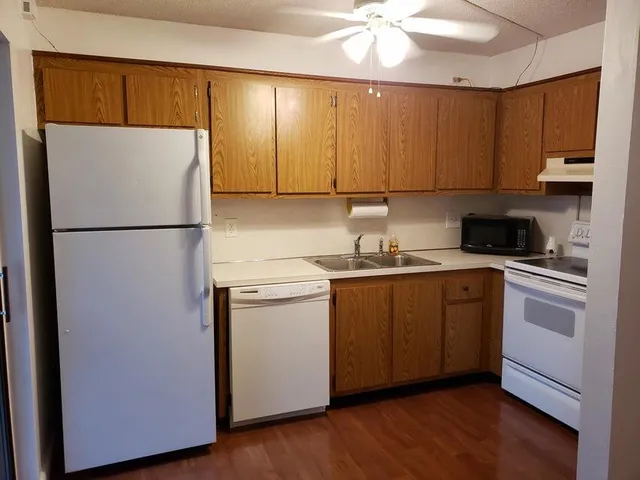 a kitchen with a refrigerator sink and cabinets