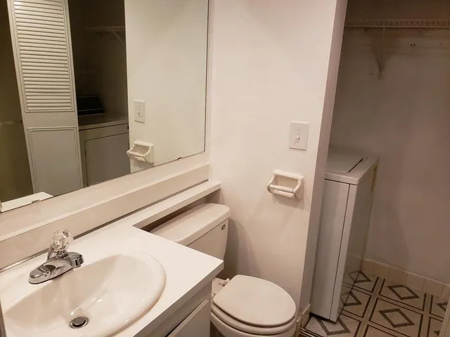 a white toilet sitting next to a bathroom sink