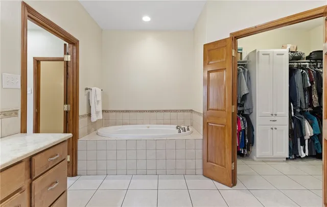 a bathroom with a tub a sink and a mirror