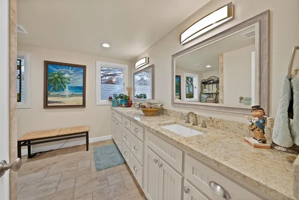 a spacious bathroom with a granite countertop sink and a mirror