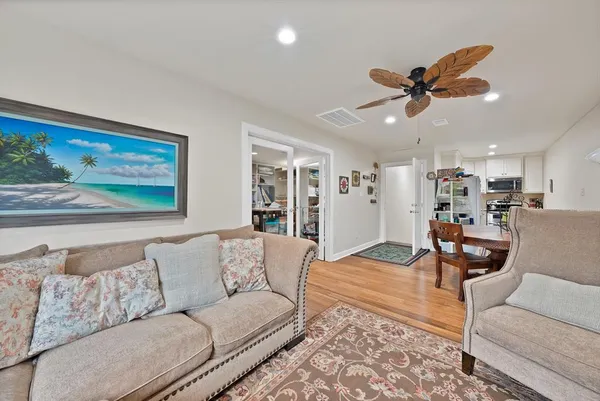a living room with furniture and a view of kitchen