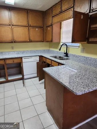 a kitchen with a sink a stove and cabinets