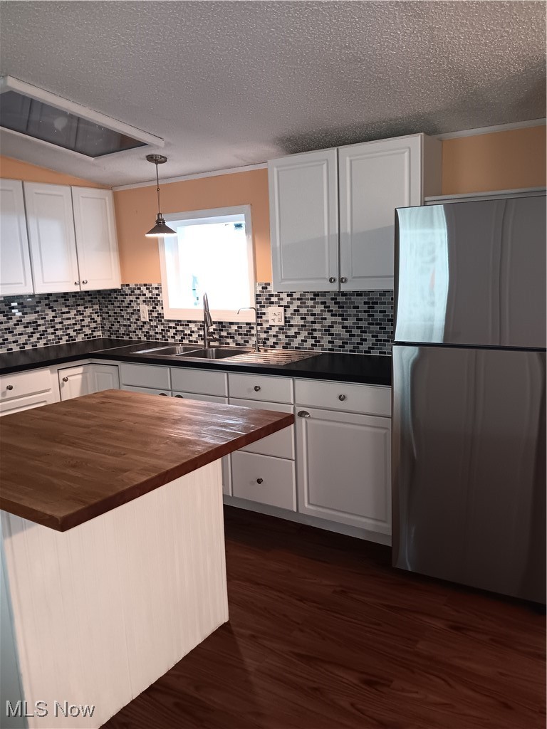 76241 Old Twenty One Road Kimbolton, OH 43749 - Photo 11 of 36 Kitchen with butcher block countertops, fridge, dark wood-type flooring, a textured ceiling, and white cabinetry