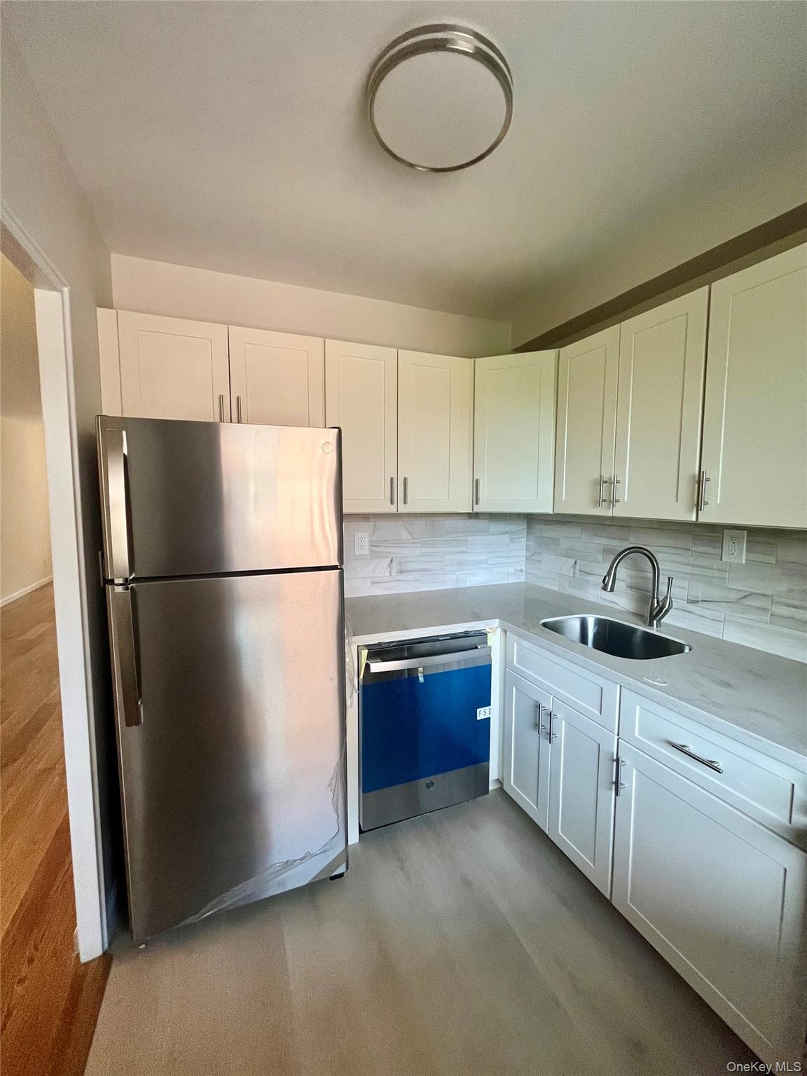 4901 Henry Hudson Parkway West, Unit 9F Bronx, NY 10471 - Photo 11 of 17 a kitchen with stainless steel appliances granite countertop a refrigerator sink and cabinets