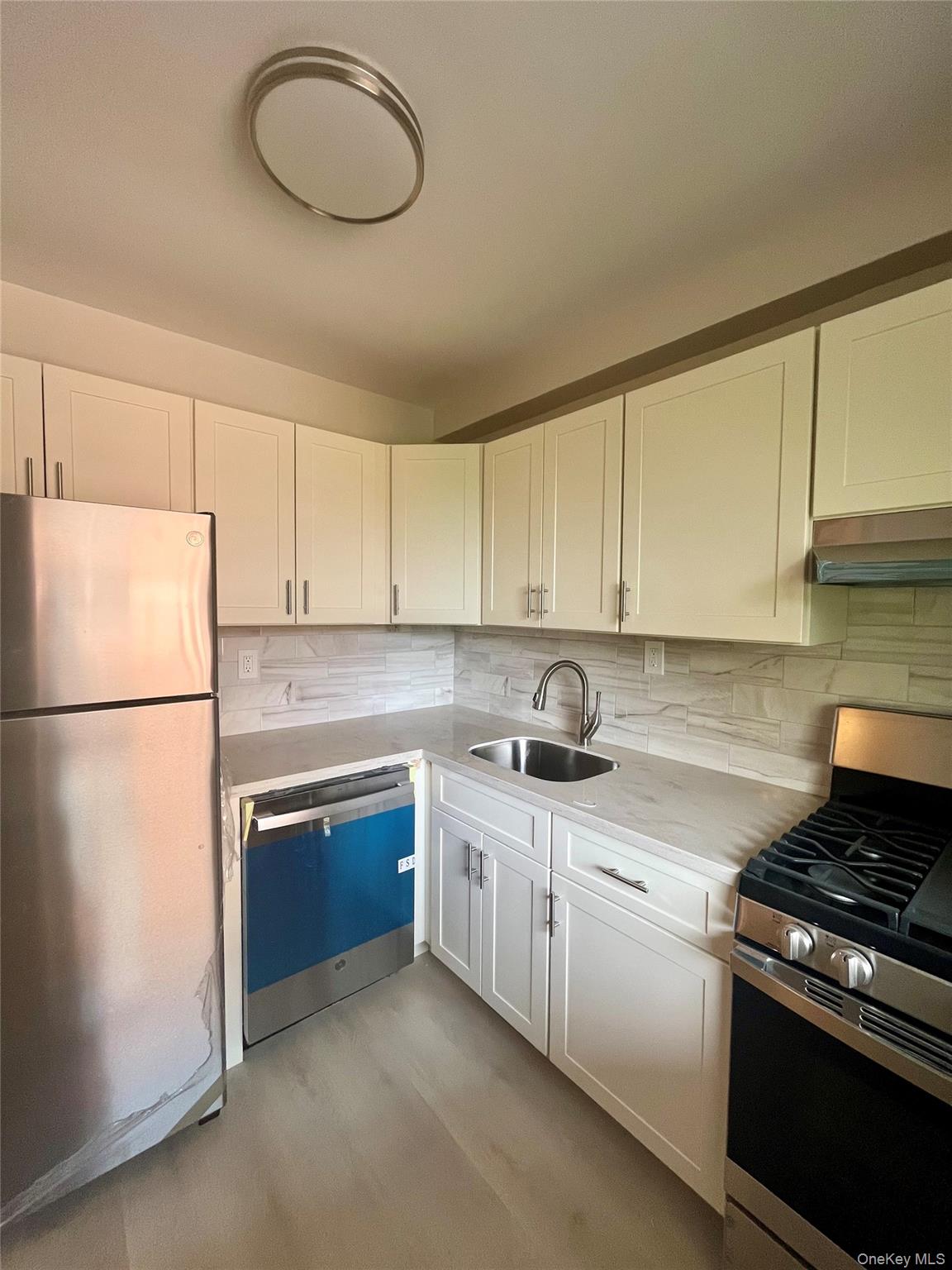 4901 Henry Hudson Parkway West, Unit 9F Bronx, NY 10471 - Photo 12 of 17 a kitchen with stainless steel appliances granite countertop a sink stove and refrigerator