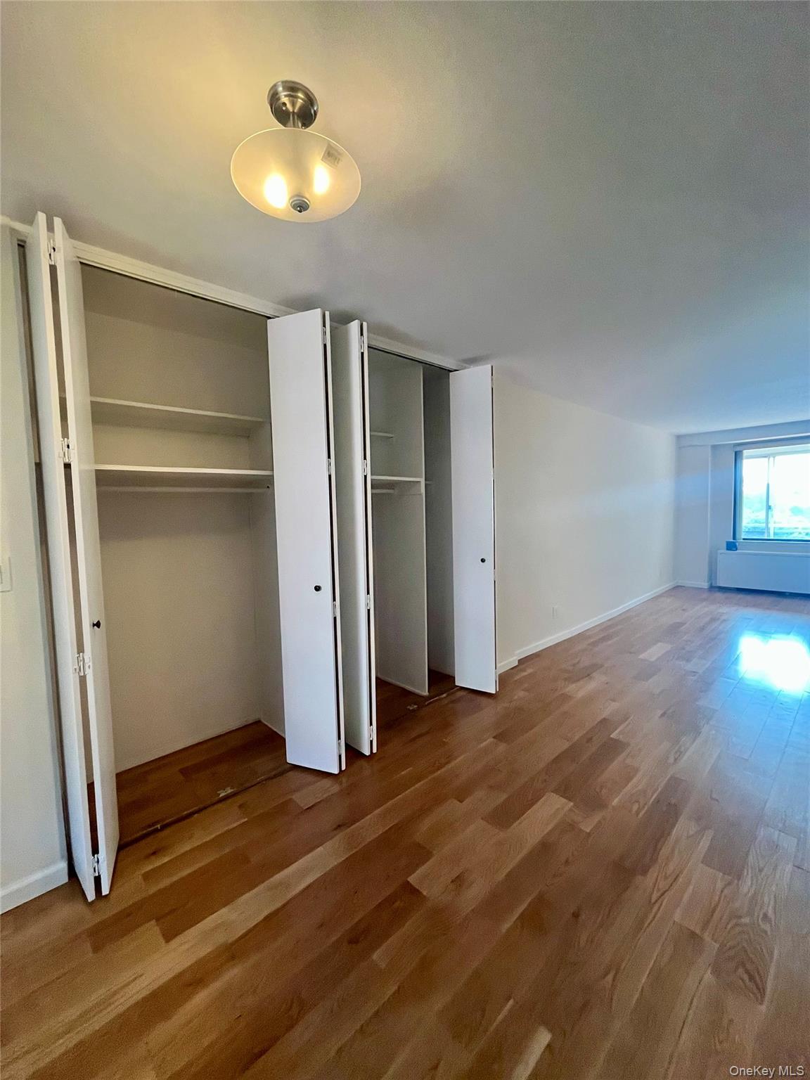 4901 Henry Hudson Parkway West, Unit 9F Bronx, NY 10471 - Photo 3 of 17 a view of empty room with wooden floor and fan
