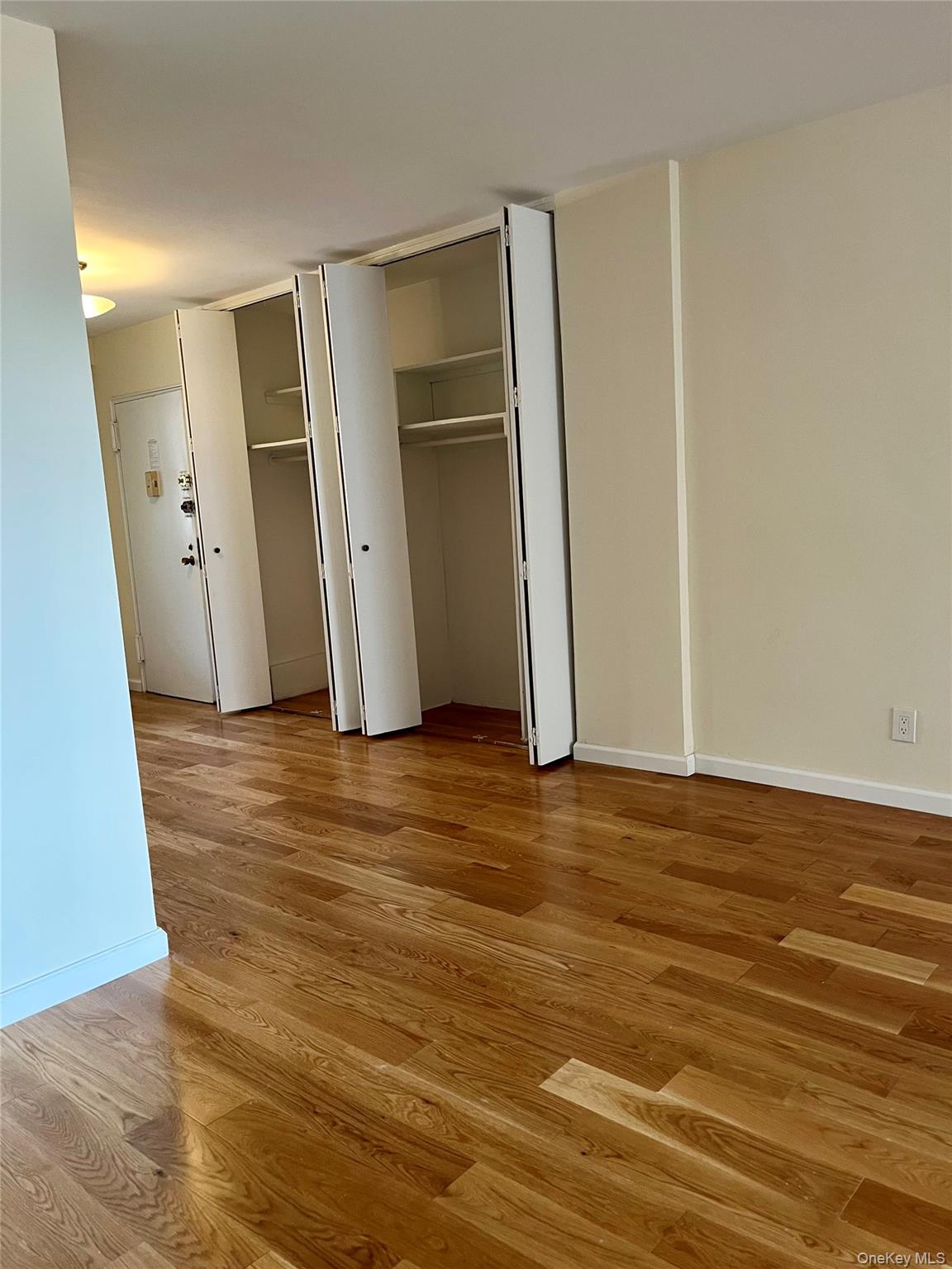 4901 Henry Hudson Parkway West, Unit 9F Bronx, NY 10471 - Photo 4 of 17 an empty room with wooden floor and entrance