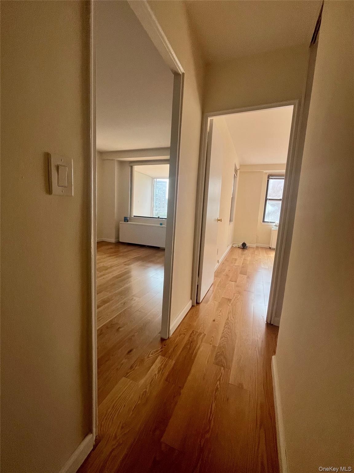 4901 Henry Hudson Parkway West, Unit 9F Bronx, NY 10471 - Photo 9 of 17 a view of a hallway with wooden floor and a living room