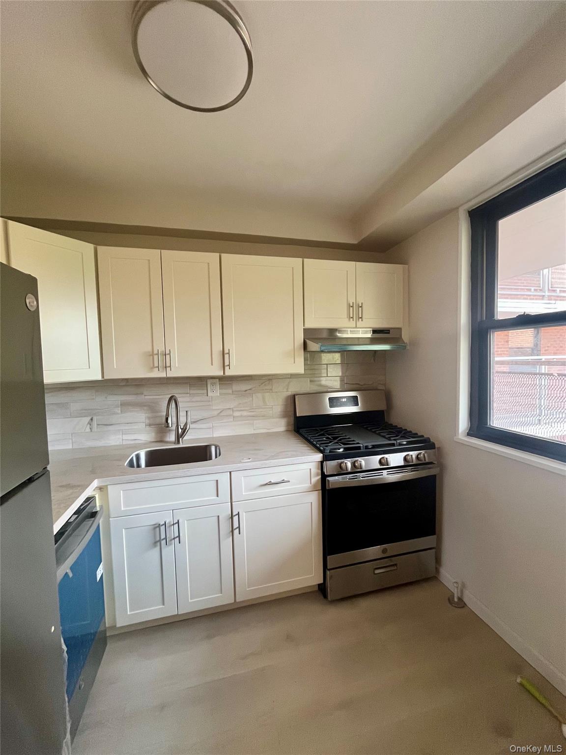 4901 Henry Hudson Parkway West, Unit 9F Bronx, NY 10471 - Photo 10 of 17 a kitchen with a stove a sink and a window