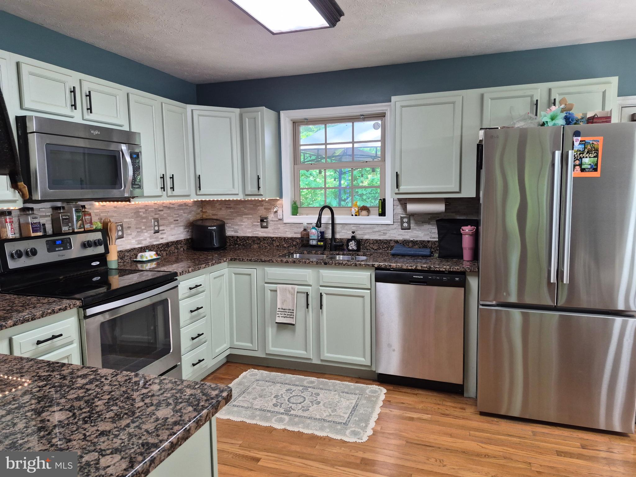 1440 Drummer Hill Road Front Royal, VA 22630 - Photo 22 of 42 a kitchen with granite countertop a refrigerator stove and microwave