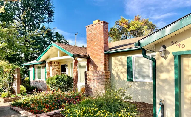 a view of yellow house in front of a big yard