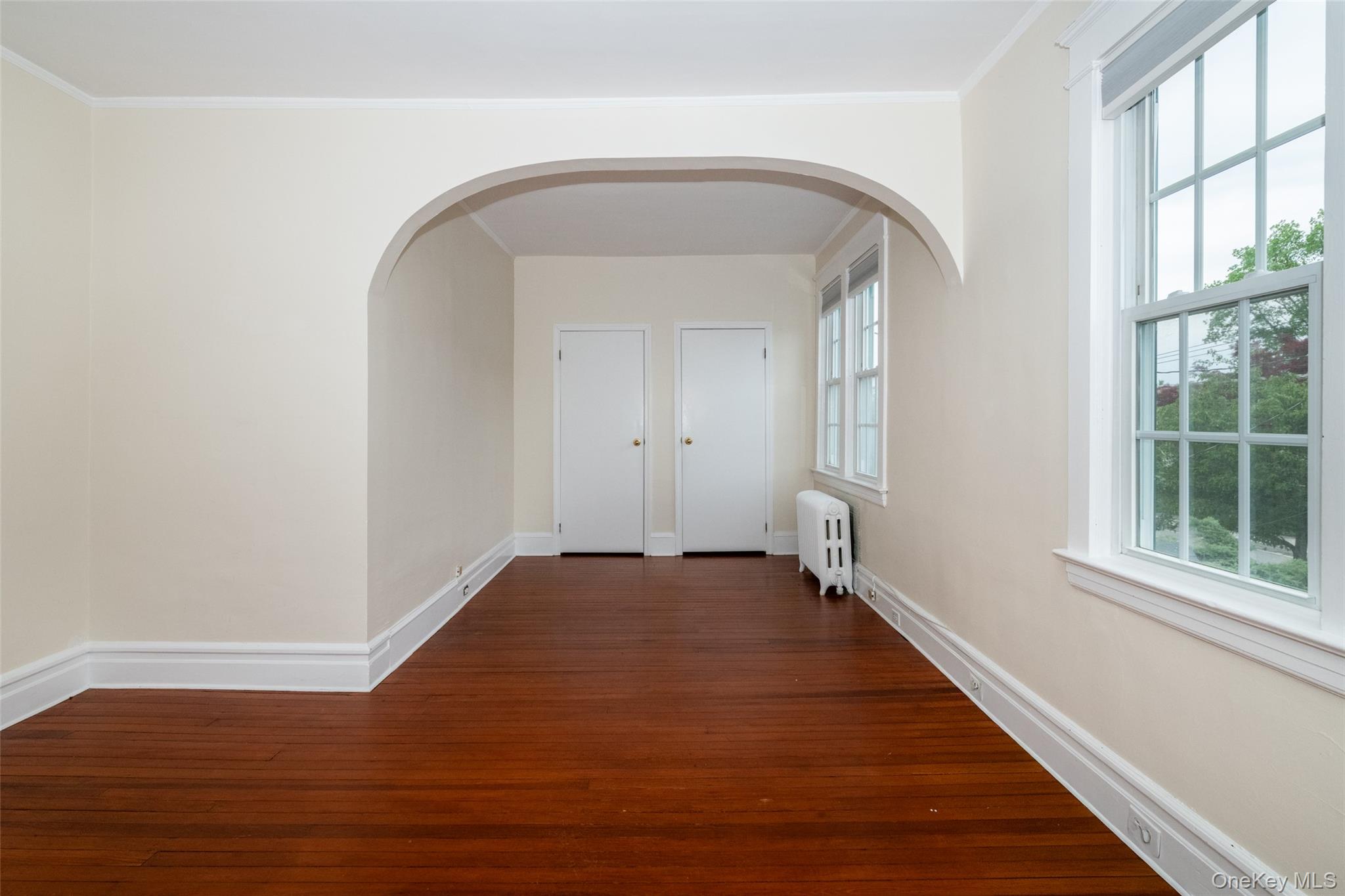 82 Clove Road New Rochelle, NY 10801 - Photo 16 of 39 an empty room with wooden floor and windows