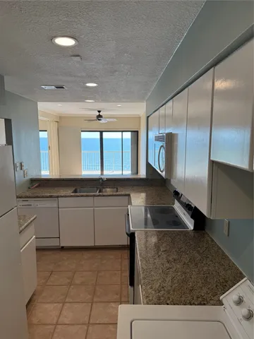 a large kitchen with kitchen island granite countertop a large counter top and a stove