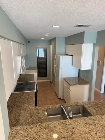 a view of a refrigerator in kitchen and living room