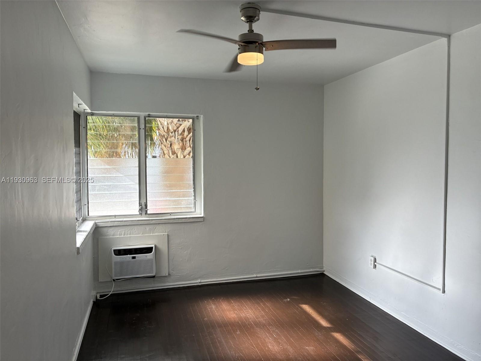 2469 Flamingo Place, Unit 2 Miami Beach, FL 33140 - Photo 17 of 22 an empty room with wooden floor fan and windows