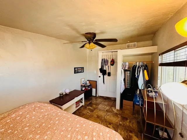 a bed room with a bed and a ceiling fan