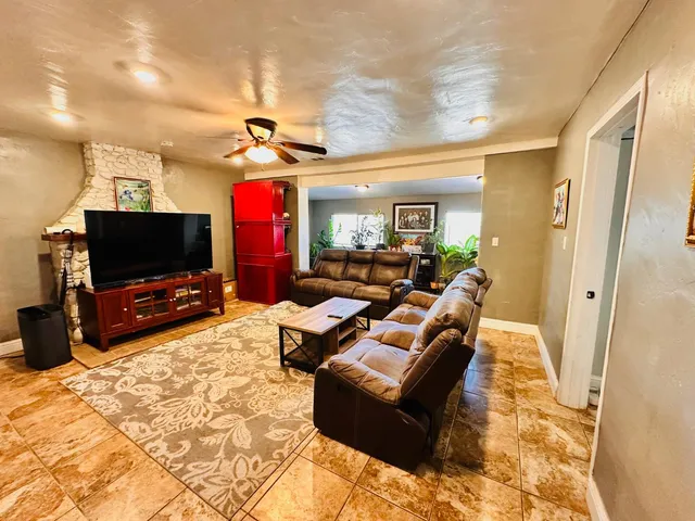 a living room with furniture a flat screen tv and a view of kitchen
