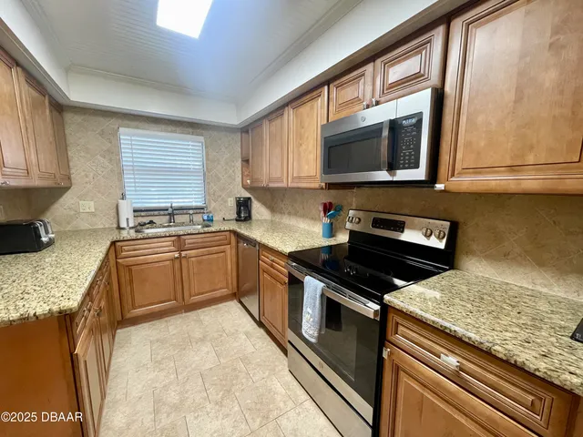 a kitchen with stainless steel appliances granite countertop a stove a sink and a microwave