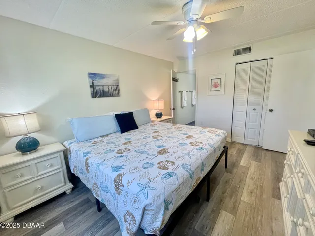 a bedroom with a bed and a lamp on dresser