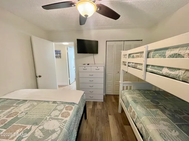 a spacious bedroom with a bed and flat screen tv