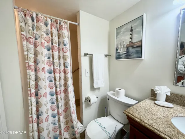 a bathroom with a granite countertop toilet and a sink