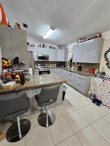 a kitchen with stainless steel appliances kitchen island granite countertop a sink and cabinets