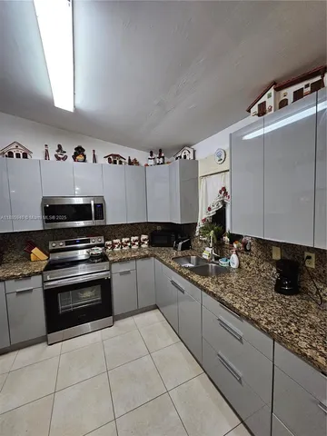 a kitchen with stainless steel appliances granite countertop a sink and cabinets