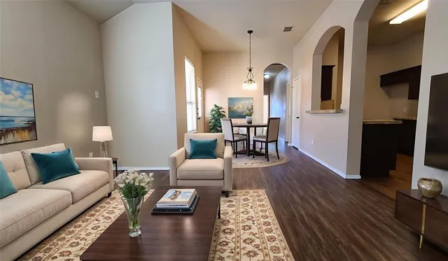 a living room with furniture and wooden floor