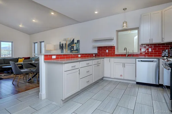a kitchen with white cabinets and sink