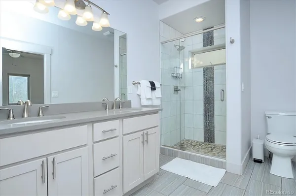 a bathroom with a granite countertop sink mirror and shower
