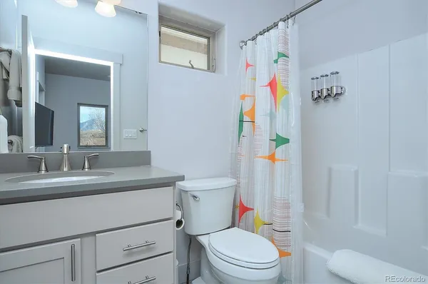 a bathroom with a toilet sink vanity and mirror