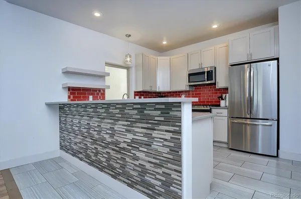 a kitchen with refrigerator and a sink