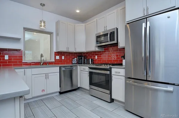 a kitchen with stainless steel appliances a stove microwave and refrigerator