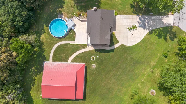an aerial view of a house with swimming pool and outdoor seating