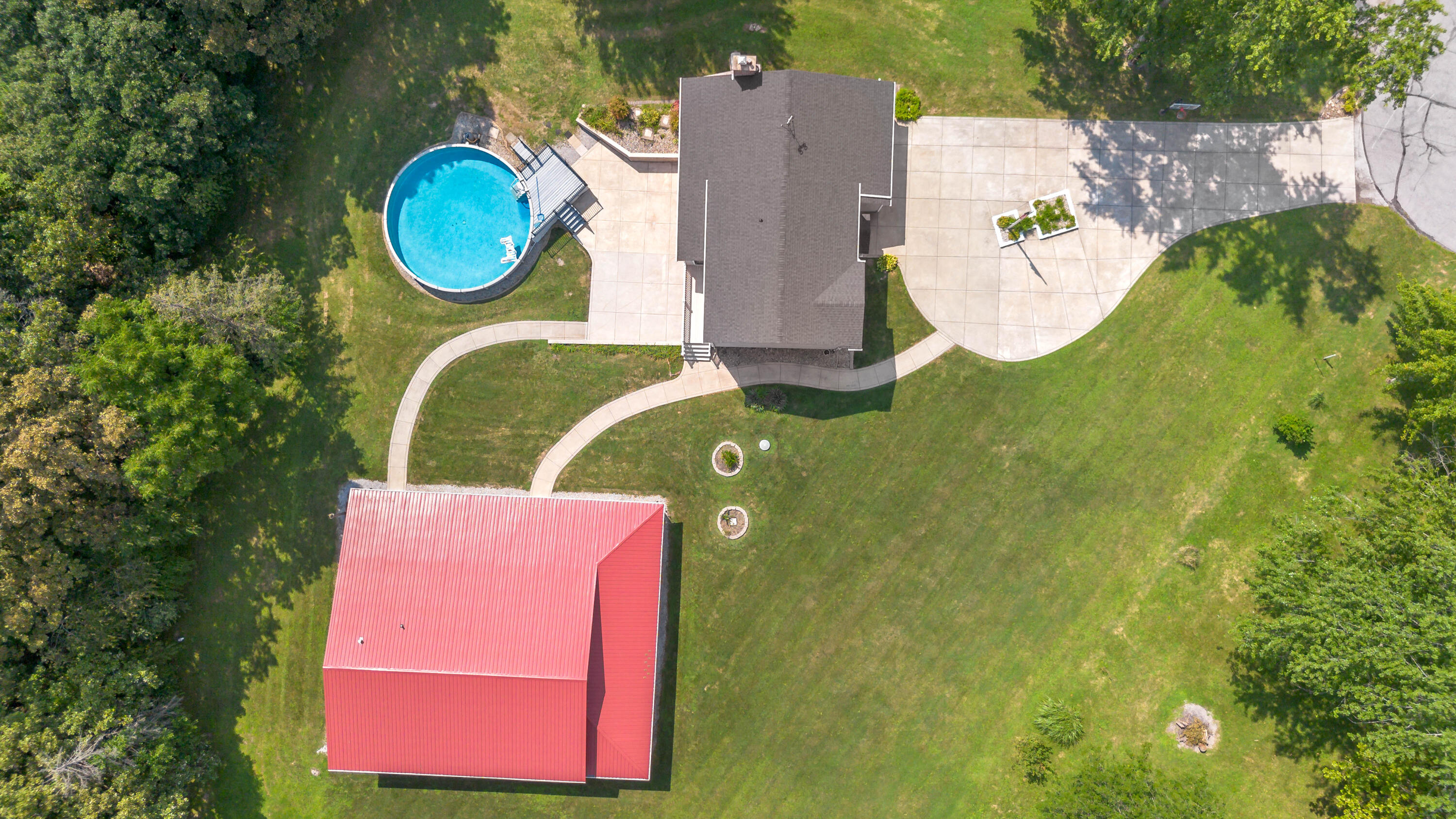 an aerial view of a house with swimming pool and outdoor seating