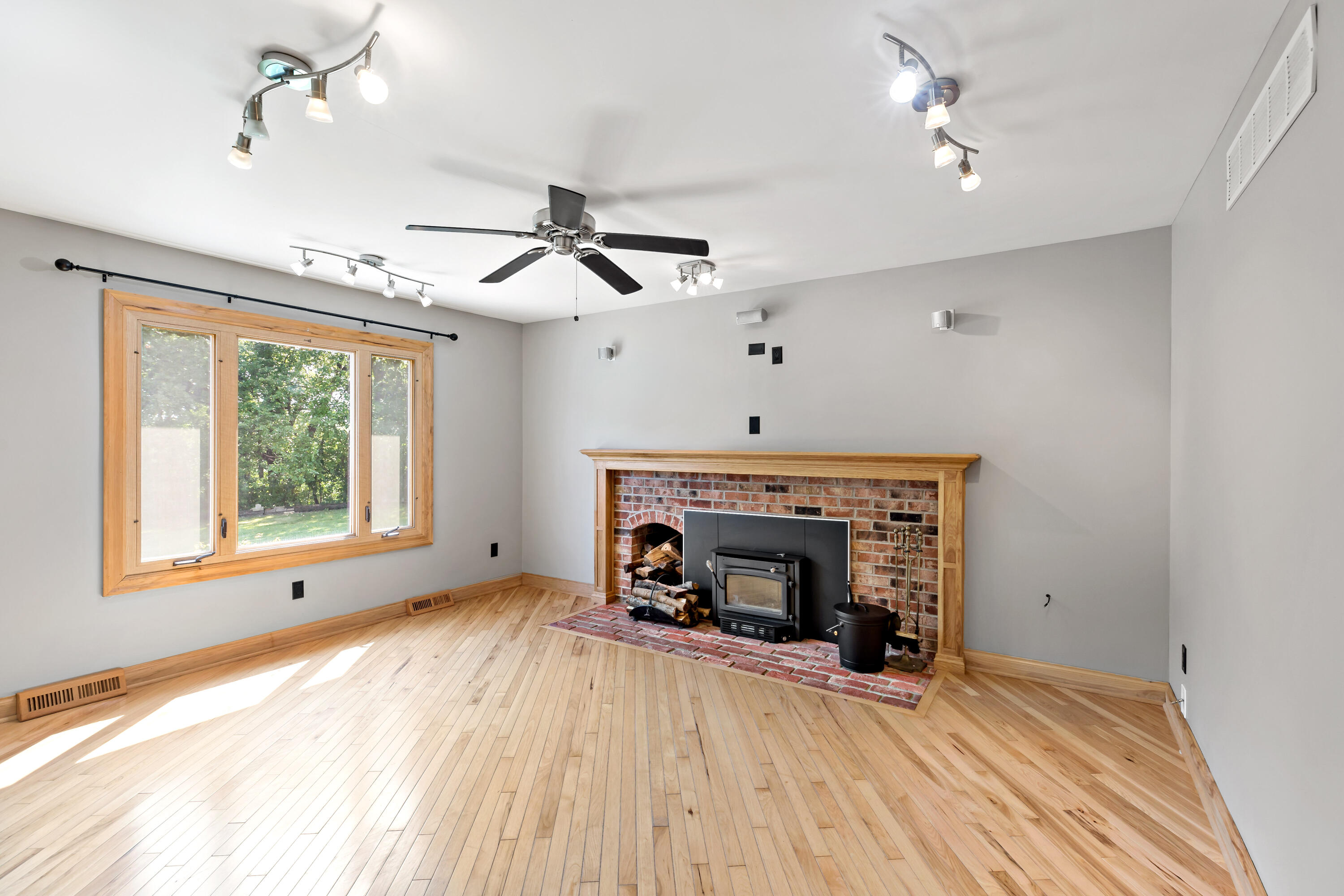 5496 West 107th Court Crown Point, IN 46307 - Photo 14 of 48 a view of an empty room with wooden floor fireplace and a window