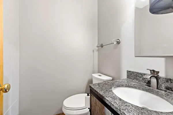 a bathroom with a granite countertop sink a toilet and mirror
