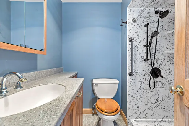 a bathroom with a granite countertop toilet sink and mirror