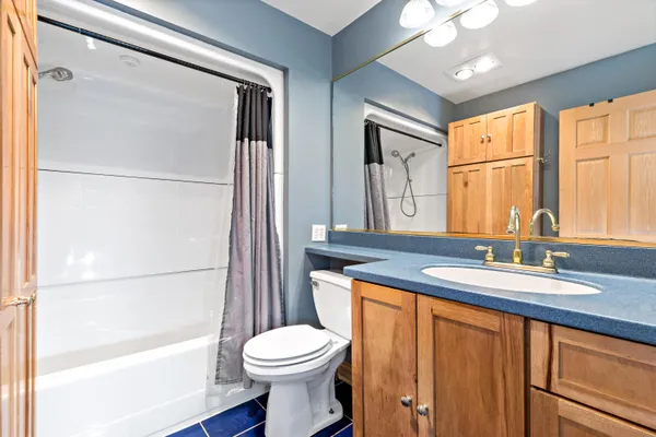 a bathroom with a granite countertop sink toilet a mirror and shower