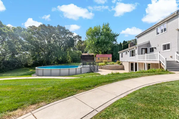 a front view of house with yard and trees in the background