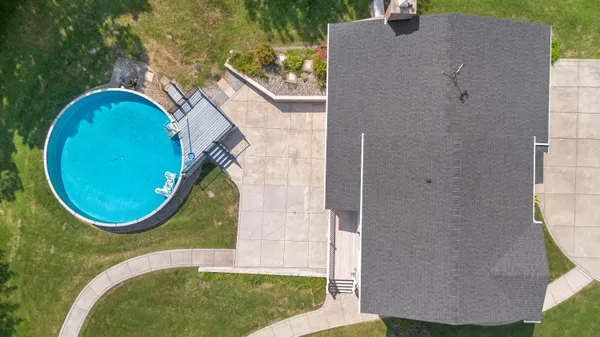 an aerial view of a house with outdoor space pool seating area and yard