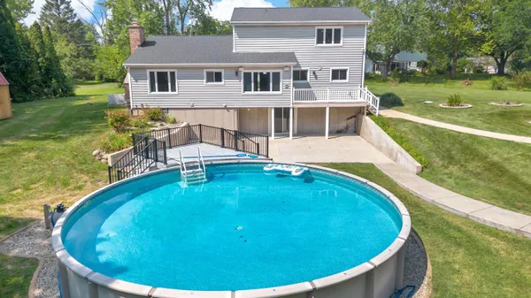 a view of a house with a swimming pool and yard
