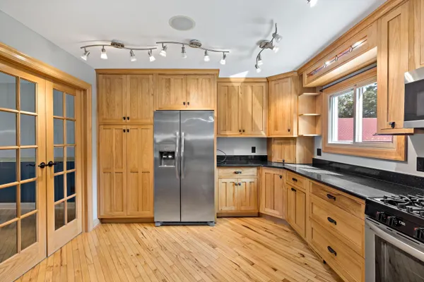 a kitchen with stainless steel appliances granite countertop a refrigerator and a sink