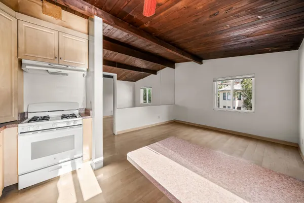 a view of a kitchen with wooden floor and electronic appliances