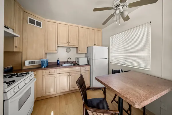 a kitchen with a table chairs refrigerator and cabinets